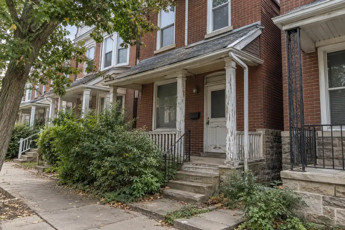 A house with peeling paint and worn roof shingles that needs repairs